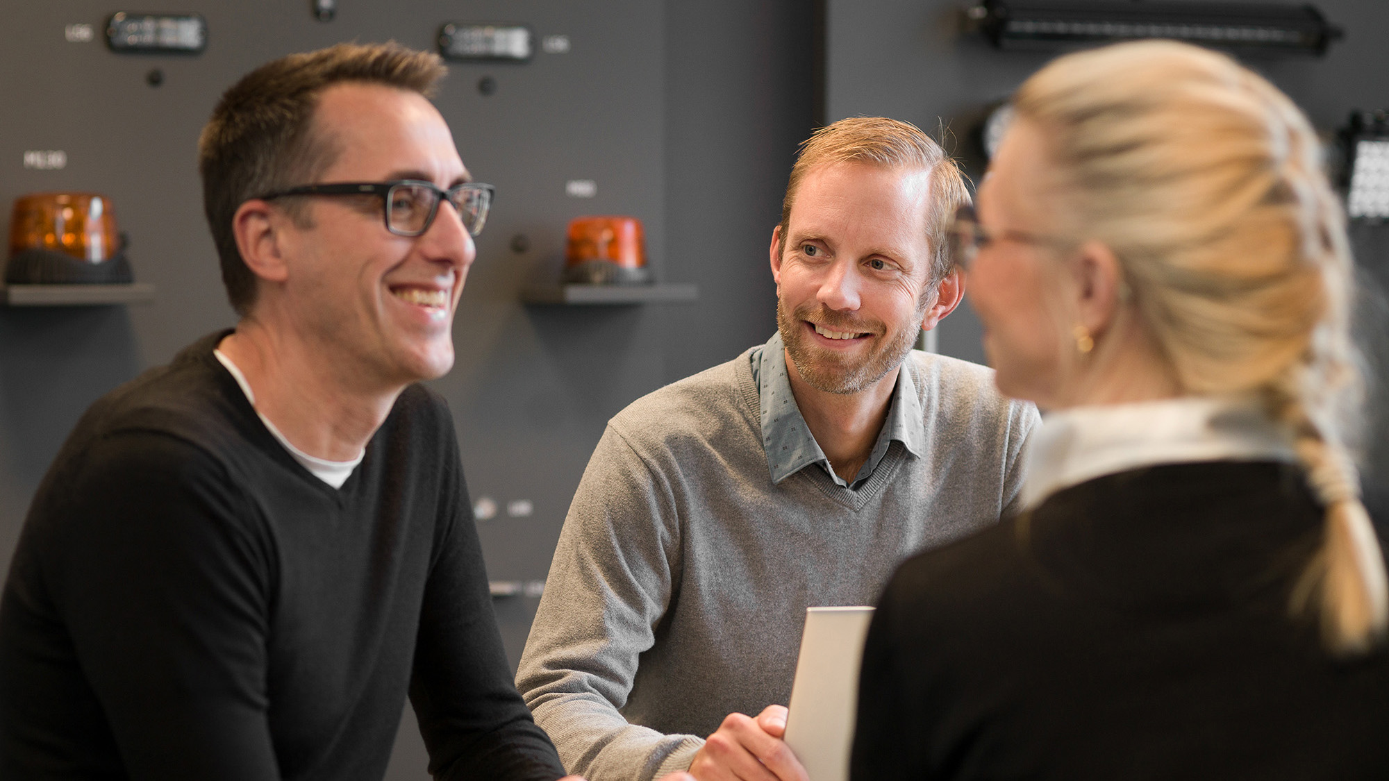 Tre medarbetare sitter i ett möte och pratar.